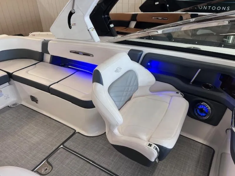 Slide: The Image of Interior of 2021 Chaparral 307 SSX boat with white seating and blue accent lighting. - 12