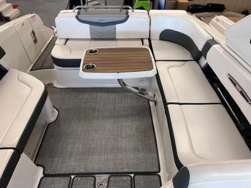 Slide: The Image of 2021 Chaparral 307 SSX boat interior with seating and a wooden table. - 25