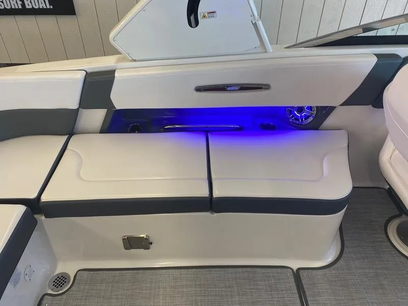 Slide: The Image of 2021 Chaparral 307 SSX boat interior with cushioned seating and blue LED lighting. - 26