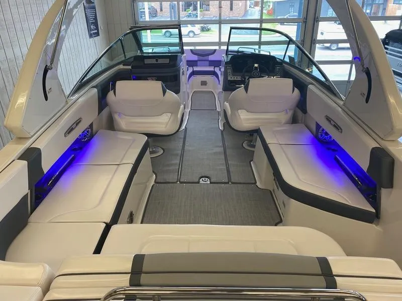 Slide: The Image of 2021 Chaparral 307 SSX boat interior with white seating and blue LED lighting. - 35