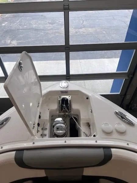 Slide: The Image of 2021 Chaparral 307 SSX boat anchor compartment with open hatch in a garage setting. - 8