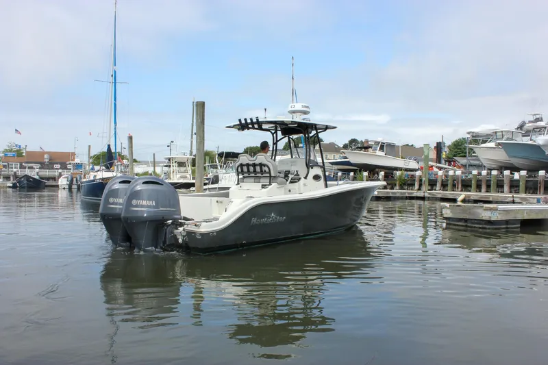 The Image of 2017 NauticStar 2602 Legacy boat with twin Yamaha engines docked in a marina. - 0