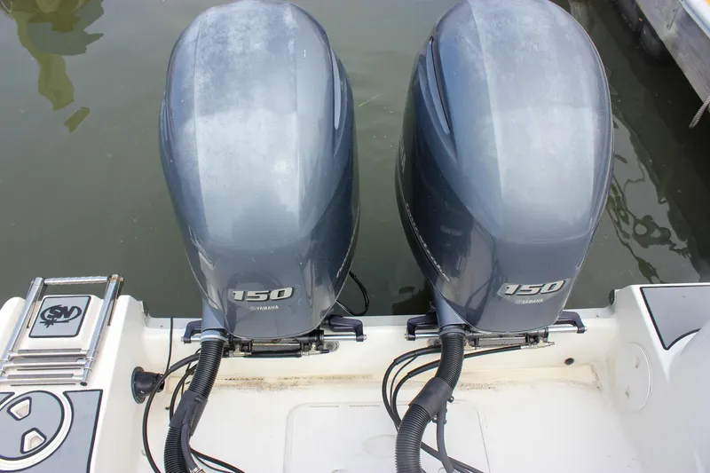 Slide: The Image of 2017 NauticStar 2602 Legacy boat stern with ladder and motor in water. - 11