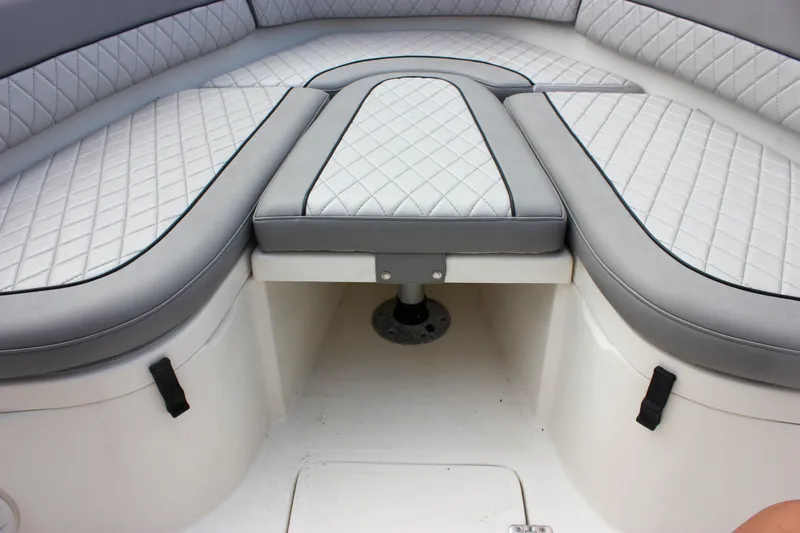 Slide: The Image of 2017 NauticStar 2602 Legacy boat with luxurious gray seating at a marina. - 18