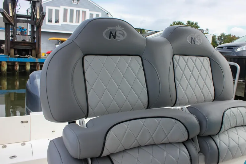 Slide: The Image of 2017 NauticStar 2602 Legacy boat interior with cushioned seating and storage hatch. - 27