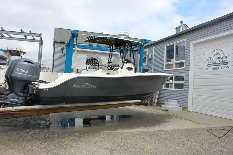 Slide: The Image of 2017 NauticStar 2602 Legacy boat on lift at marina, side view. - 48