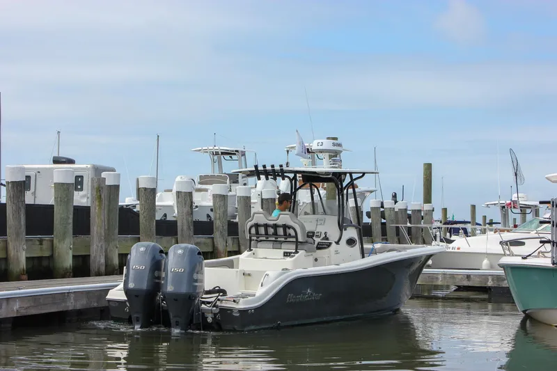 Slide: The Image of 2017 NauticStar 2602 Legacy boat docked at a marina with other vessels. - 5