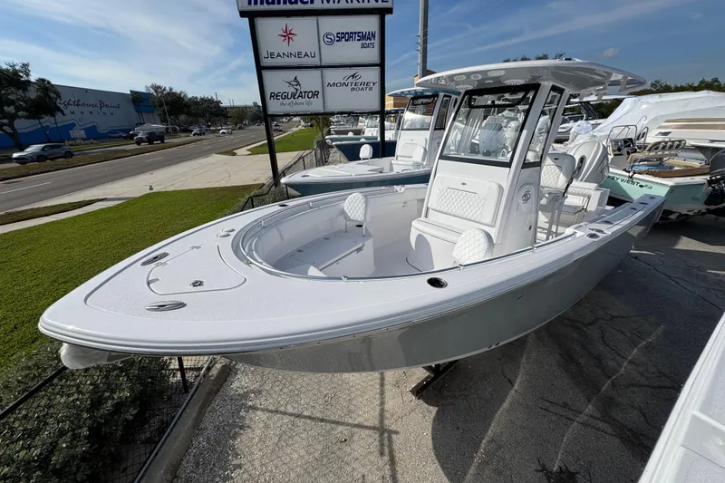 The Image of 2026 Sportsman Open 232 Center Console boat displayed at a marina dealership. - 1