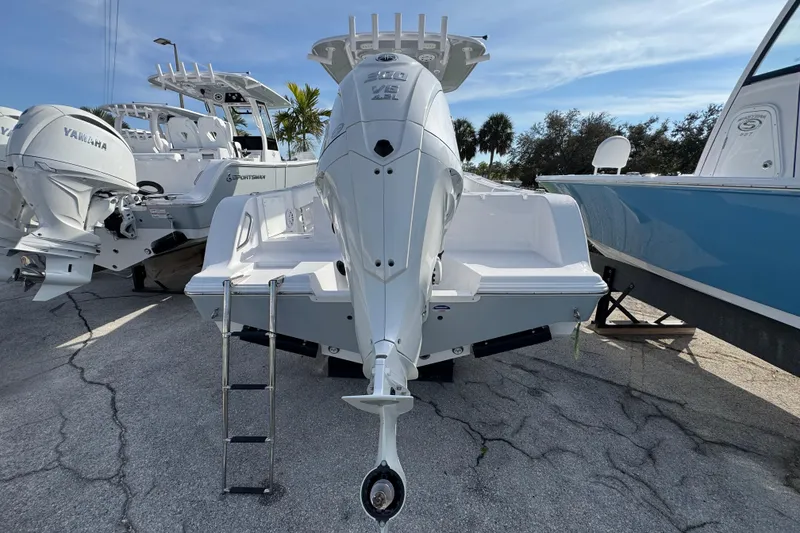 Slide: The Image of 2026 Sportsman Open 232 Center Console boat with Yamaha outboard engine, docked outdoors. - 2