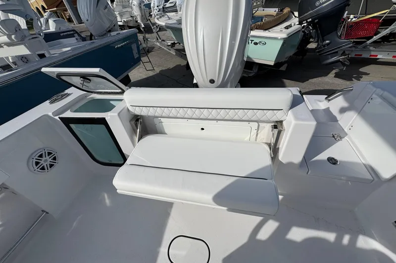 Slide: The Image of 2026 Sportsman Open 232 Center Console boat interior with white seating and storage compartments. - 4