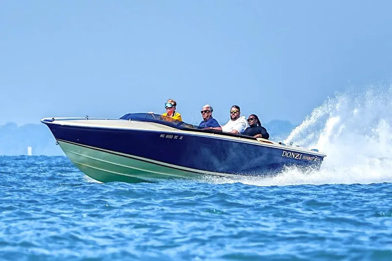 Slide: The Image of 1986 Donzi Hornet III speedboat cruising on open water with passengers. - 2