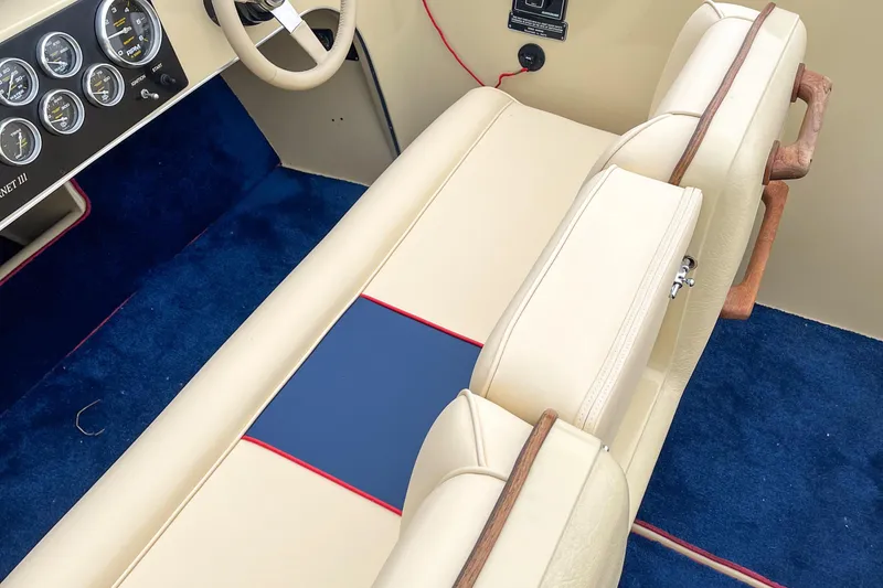 Slide: The Image of 1986 Donzi Hornet III interior with beige seats, blue carpet, and dashboard gauges. - 4