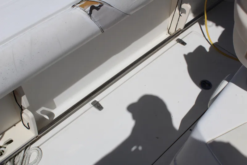 Slide: The Image of 2009 Boston Whaler 220 Outrage interior with visible wear and shadows on white surface. - 11