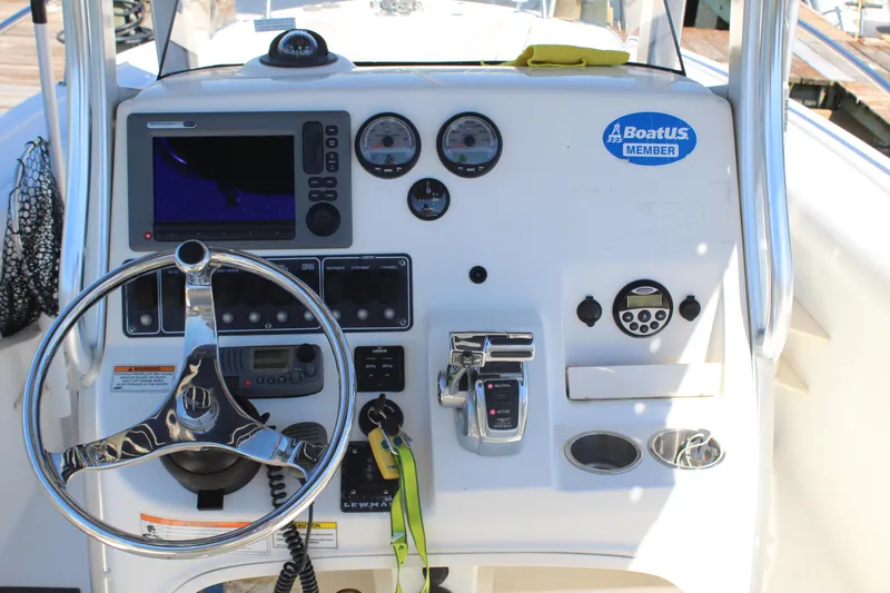 Slide: The Image of Dashboard of a 2009 Boston Whaler 220 Outrage boat with steering wheel and controls. - 12