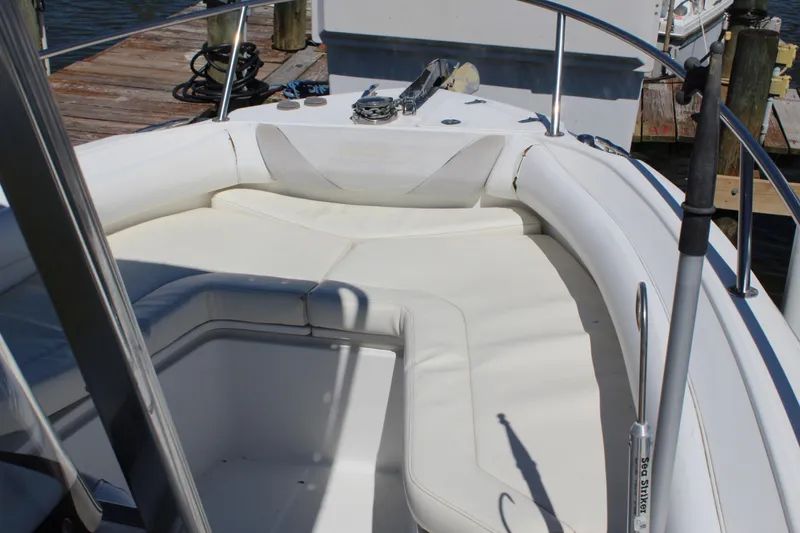 Slide: The Image of 2009 Boston Whaler 220 Outrage boat interior with white cushioned seating. - 14