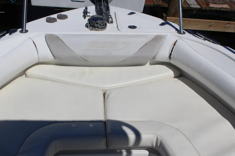 Slide: The Image of 2009 Boston Whaler 220 Outrage boat interior with white cushioned seating. - 15