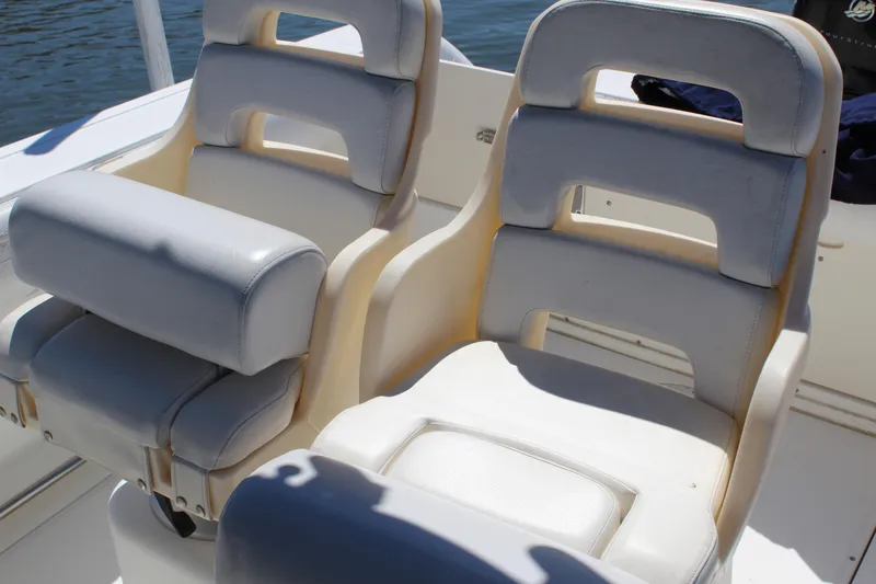 Slide: The Image of 2009 Boston Whaler 220 Outrage boat seats, white and cushioned, on a sunny day. - 18