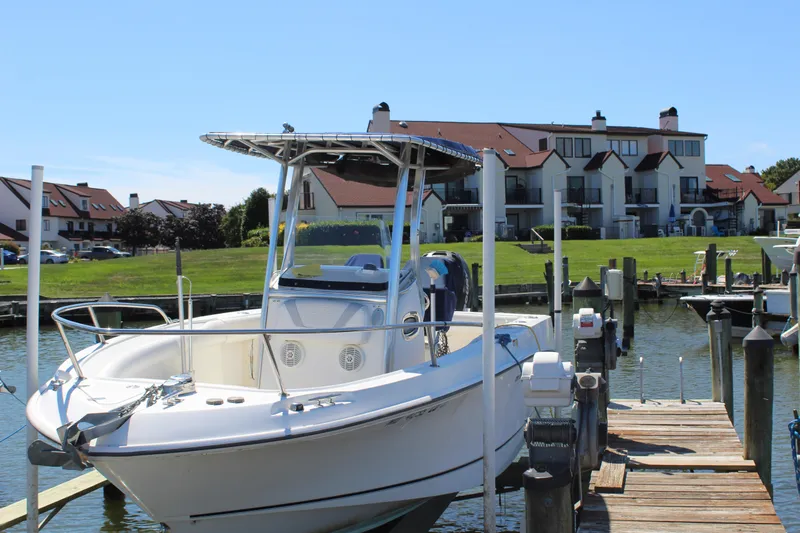 Slide: The Image of 2009 Boston Whaler 220 Outrage docked near waterfront homes on a sunny day. - 3