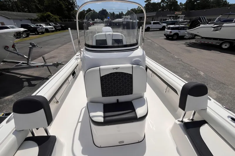 Slide: The Image of 2021 Tidewater 2500 Carolina Bay boat interior with seating and console, parked outdoors. - 11