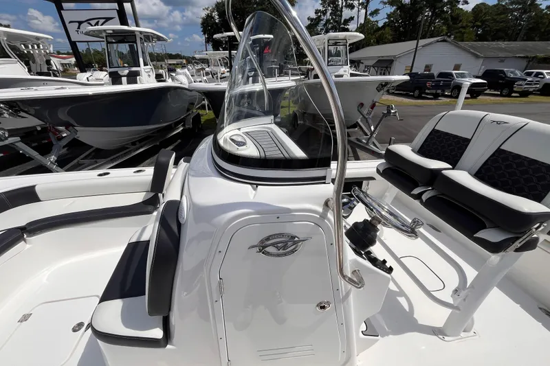 Slide: The Image of 2021 Tidewater 2500 Carolina Bay boat interior with seating and console, displayed outdoors. - 13