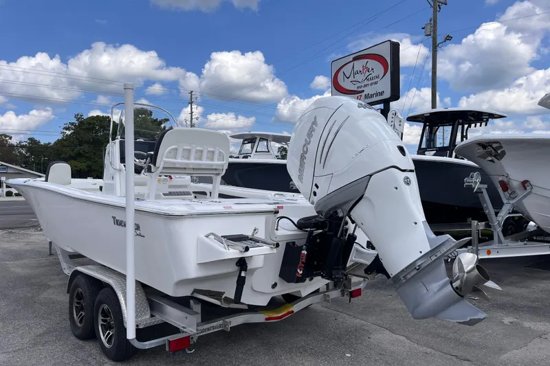 Slide: The Image of 2021 Tidewater 2500 Carolina Bay boat on trailer, featuring a powerful Mercury outboard motor. - 2