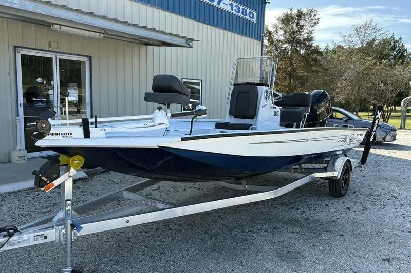 Slide: The Image of 2026 Xpress H20B Bay boat on trailer outside a building. - 5