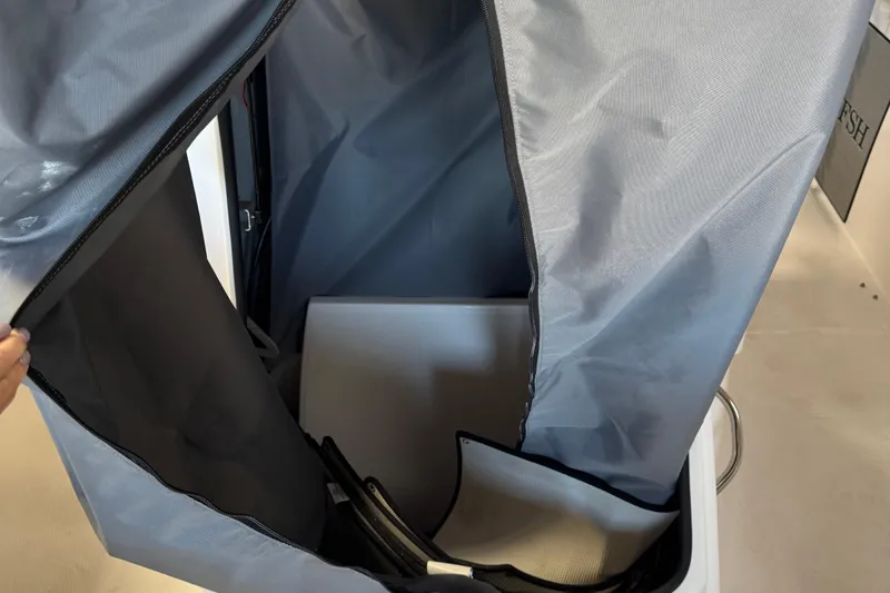 Slide: The Image of 2024 Yamaha Boats 252 FSH Sport interior storage compartment with protective cover. - 11