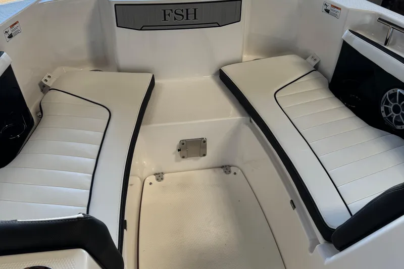 Slide: The Image of 2024 Yamaha Boats 252 FSH Sport interior seating with white cushions and sleek design. - 12