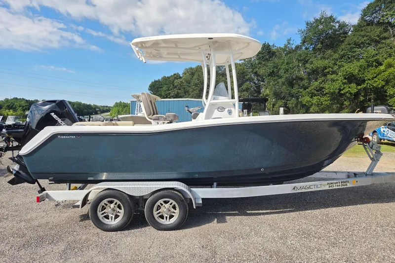 The Image of 2021 Tidewater 220 LXF boat on trailer, parked outdoors under a blue sky. - 0