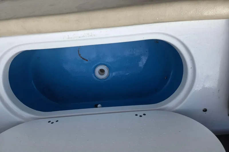Slide: The Image of Livewell compartment in a 2021 Tidewater 220 LXF boat, featuring a blue interior. - 12