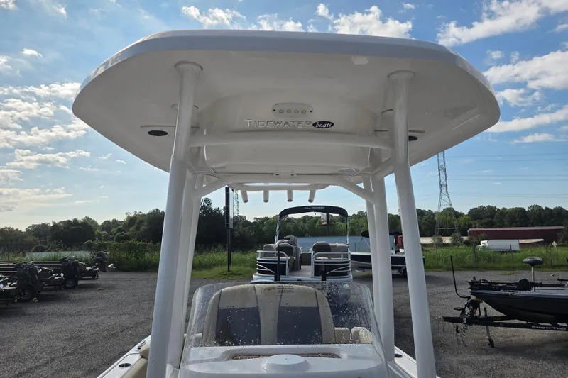 Slide: The Image of 2021 Tidewater 220 LXF boat with T-top, parked outdoors under a blue sky. - 16