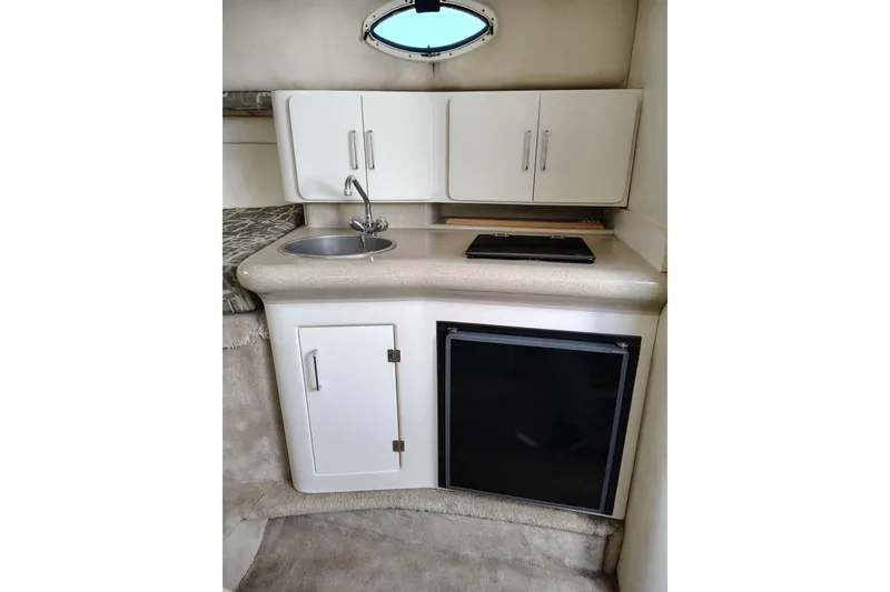 Slide: The Image of 2000 Monterey 296 Cruiser kitchenette with sink, cabinets, and mini-fridge. - 7