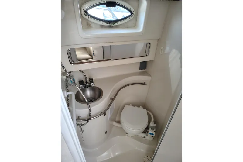 Slide: The Image of Compact bathroom in 2000 Monterey 296 Cruiser with sink, toilet, and porthole window. - 8