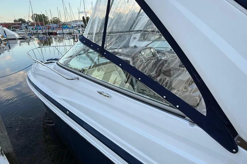 Slide: The Image of 2018 Regal 28 Express boat docked at marina with clear canopy. - 12