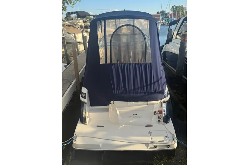 Slide: The Image of 2018 Regal 28 Express boat docked with blue canopy cover. - 13