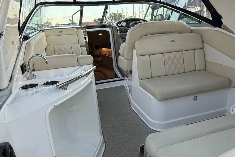 Slide: The Image of 2018 Regal 28 Express boat interior with beige seating and compact kitchenette. - 16
