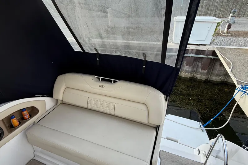 Slide: The Image of 2018 Regal 28 Express boat interior with beige seating and storage compartments. - 17