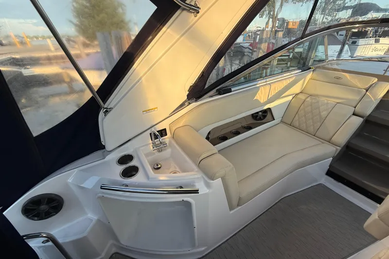 Slide: The Image of Interior of 2018 Regal 28 Express boat with beige seating and built-in cup holders. - 19