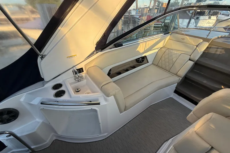 Slide: The Image of 2018 Regal 28 Express boat interior with beige seating and built-in cup holders. - 20