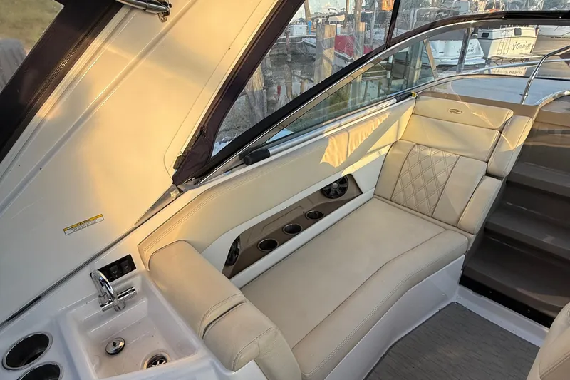 Slide: The Image of 2018 Regal 28 Express boat interior with beige seating and built-in sink. - 21