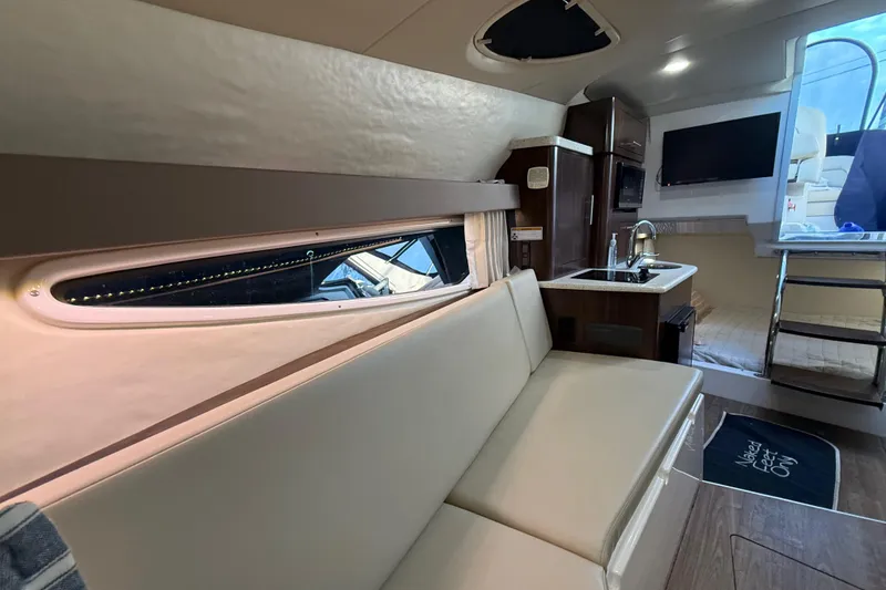 Slide: The Image of 2018 Regal 28 Express boat interior with kitchenette, seating, and modern amenities. - 27
