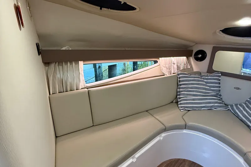 Slide: The Image of Interior of 2018 Regal 28 Express boat with beige seating and striped pillows. - 30