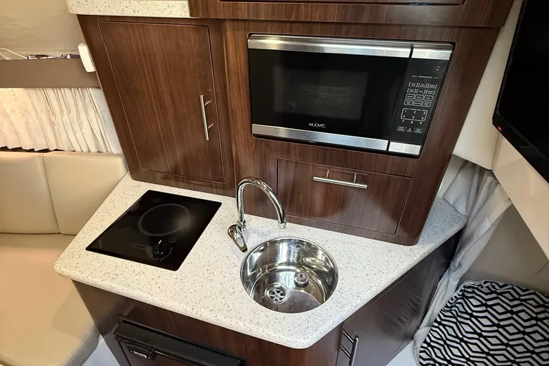 Slide: The Image of Compact kitchen in 2018 Regal 28 Express boat with microwave, sink, and cooktop. - 34