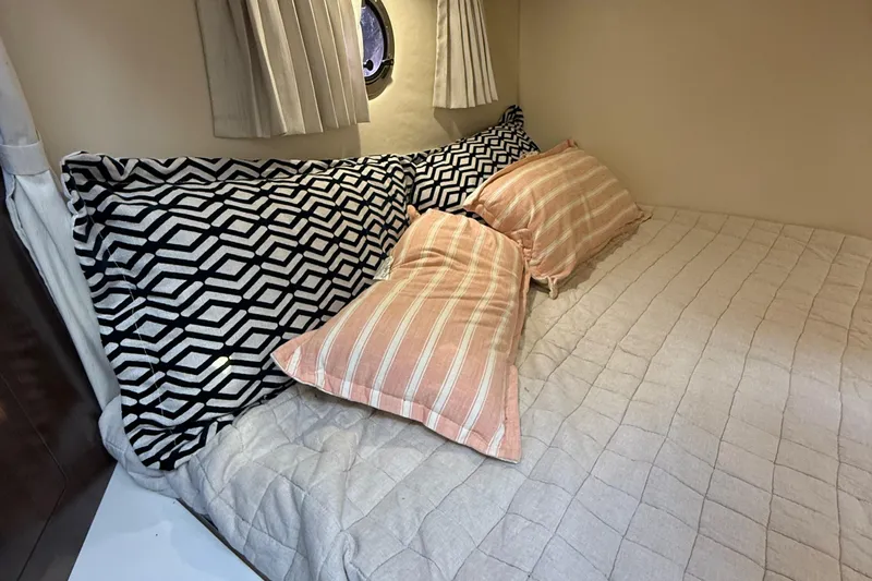 Slide: The Image of Cozy cabin bed in 2018 Regal 28 Express boat with patterned pillows and curtains. - 37