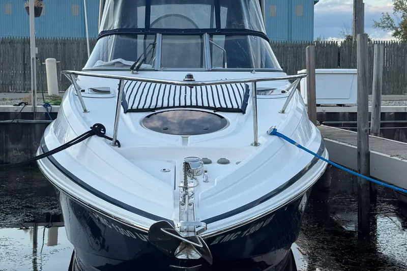 Slide: The Image of 2018 Regal 28 Express boat docked, front view with ropes and anchor visible. - 7