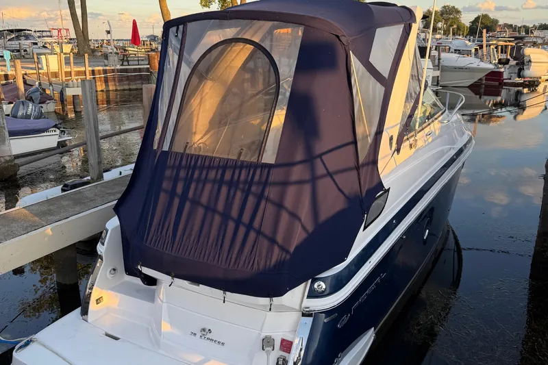 Slide: The Image of 2018 Regal 28 Express boat docked with navy canopy in marina setting. - 8