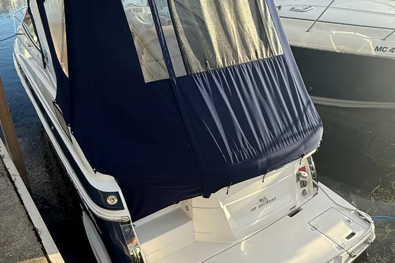 Slide: The Image of 2018 Regal 28 Express boat with blue canopy docked at marina. - 9