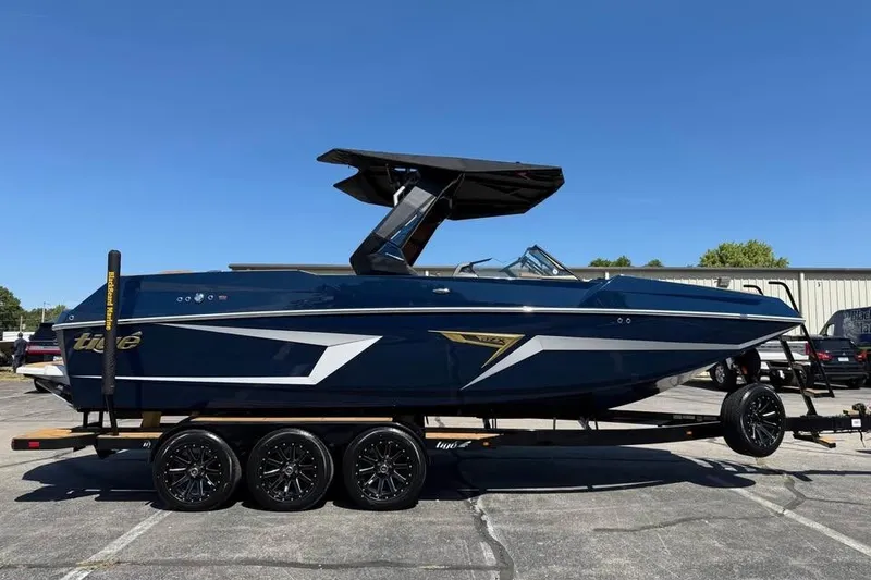 The Image of 2026 Tigé 24RZX boat on trailer, sleek design, blue exterior, sunny day. - 0