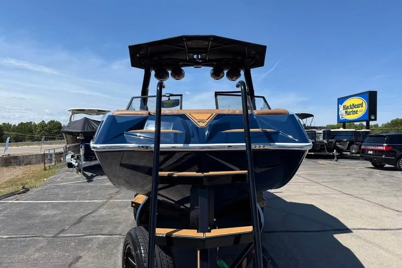 Slide: The Image of 2026 Tigé 24RZX boat displayed at BlackBeard Marine dealership under clear blue sky. - 2