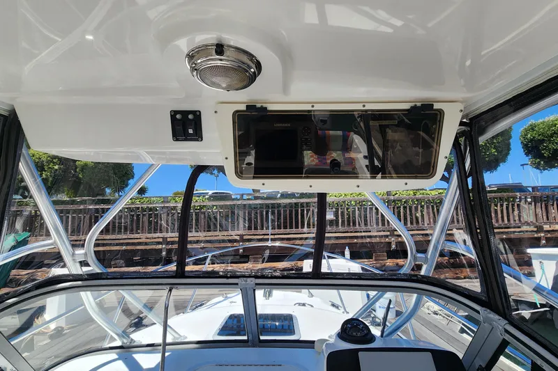 Slide: The Image of Interior view of a 2000 Boston Whaler 21 Conquest boat, showcasing the helm and dashboard. - 10